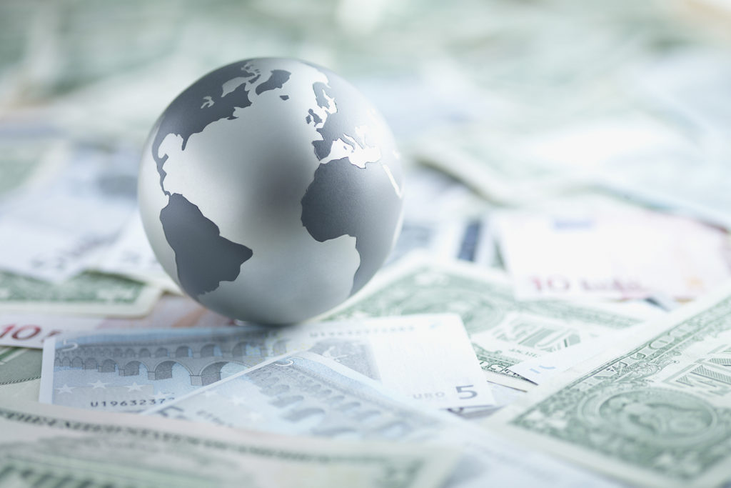 Metal globe resting on paper currency