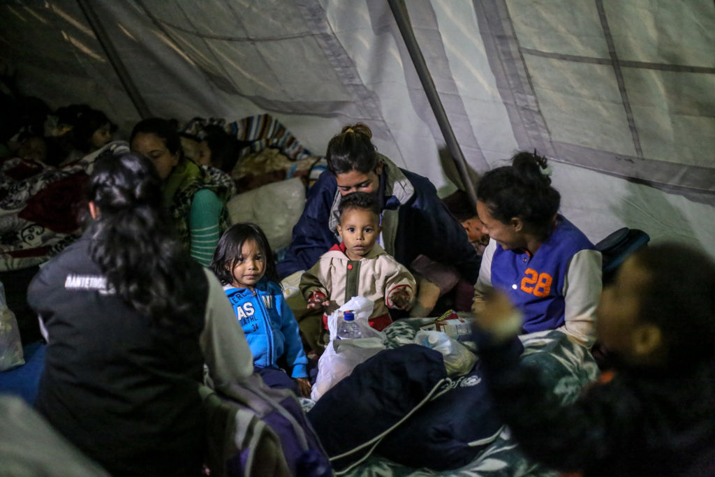 At night, migrant children and mothers gather at a UNICEF temporary rest tent in Rumichaca, Ecuadorian side of the border with Colombia.