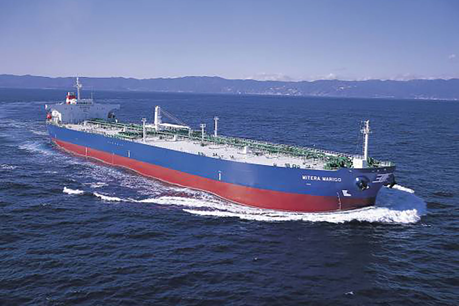 Oil tanker on the ocean with a land mass in the background