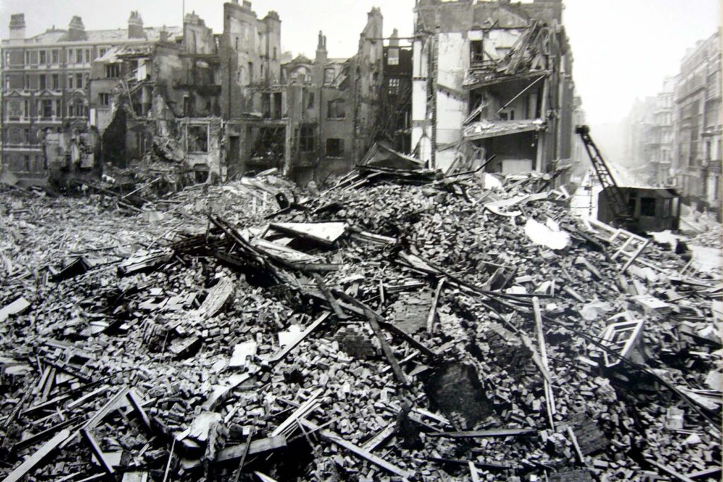 Rubble of buildings destroyed by an aerial bombing in London in WWII. Hollowed out buildings are in the background