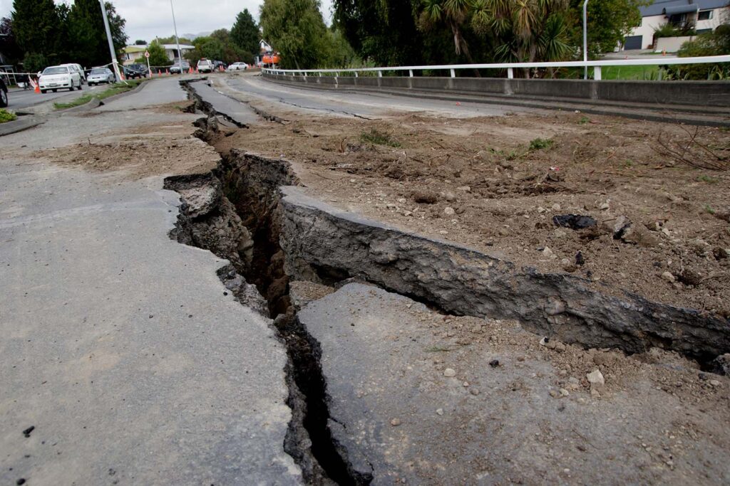 Road with a large crack in the middle extending to the end of the road