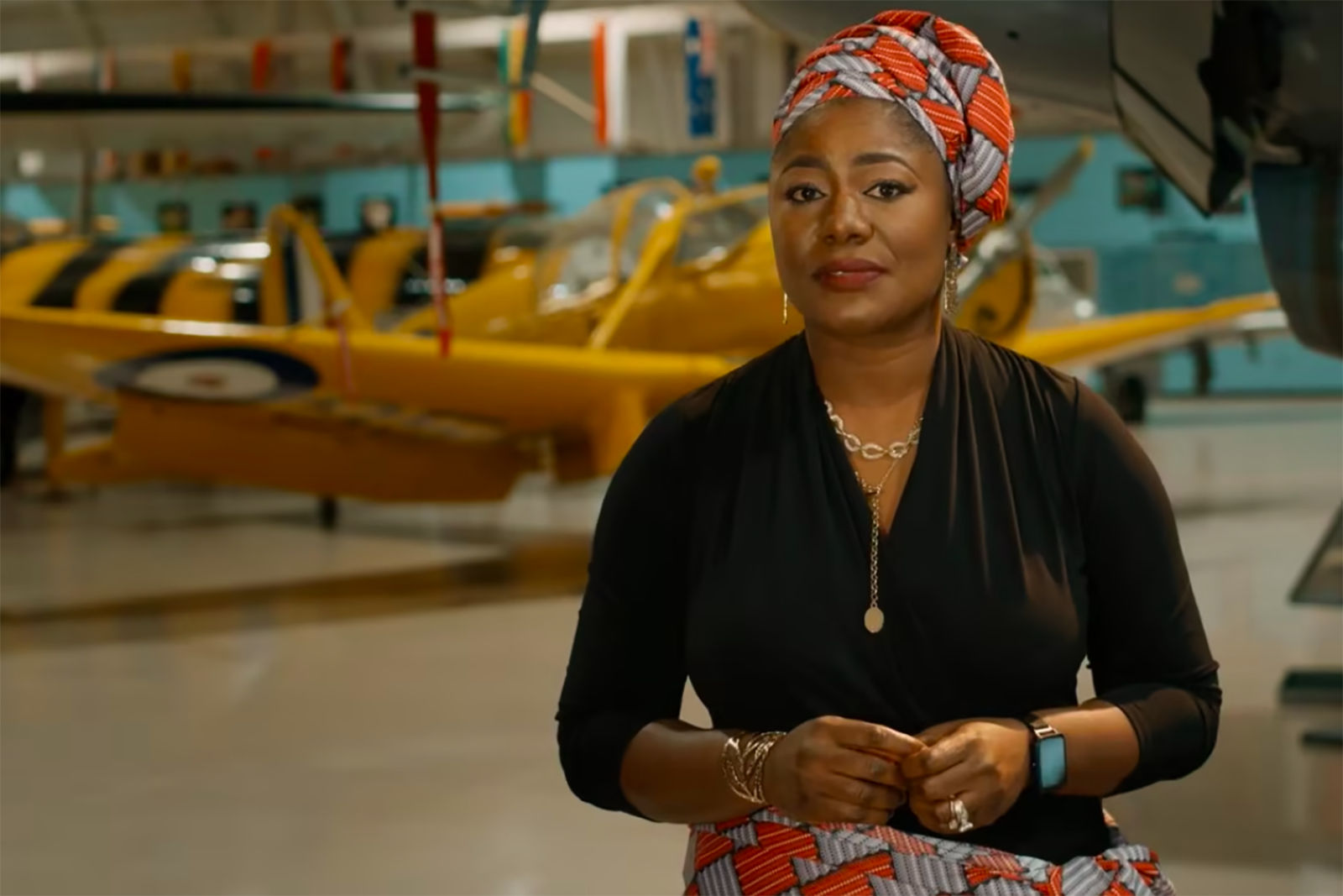 Film director, Angela Onuora, stands in front of an airplane