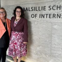 Jenna Hennebry and Allison Petrozziello stand in front of the Balsillie School sign