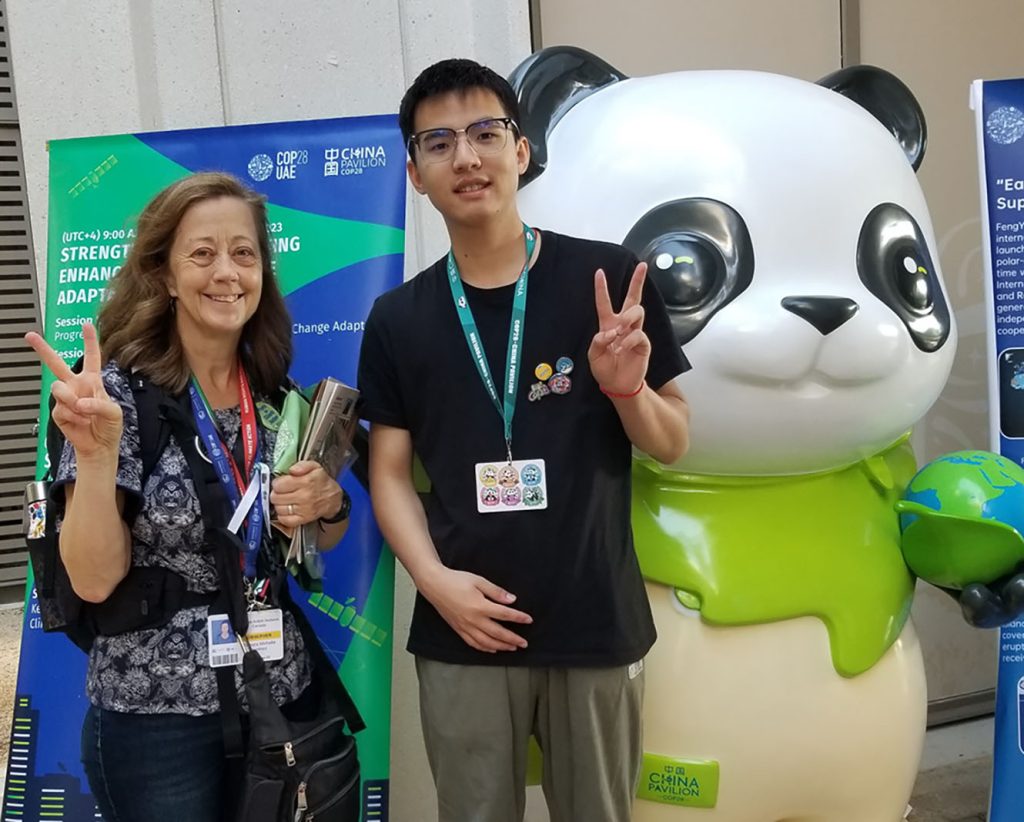 PhD student Tamara Lorincz stands with a student and a large panda statue